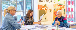 A group of people are working on a group craft at one of RISD's families weekend events.