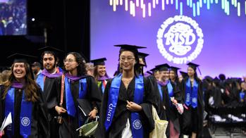 A group of RISD graduates are exiting their commencement ceremony.