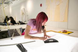 A RISD student is working taking measurements at a desk in one of our workspaces.