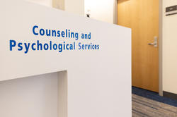 The counseling and psychological services front desk, a white desk with the office name in blue.