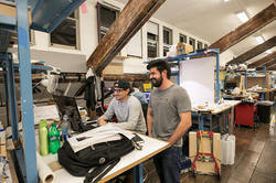 Two people collaborate on a project in a RISD workspace.